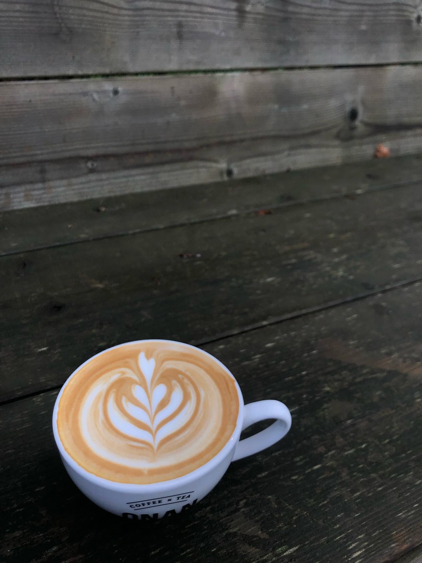 Cappuccino met een hartpatroon in het schuim op een houten tafel