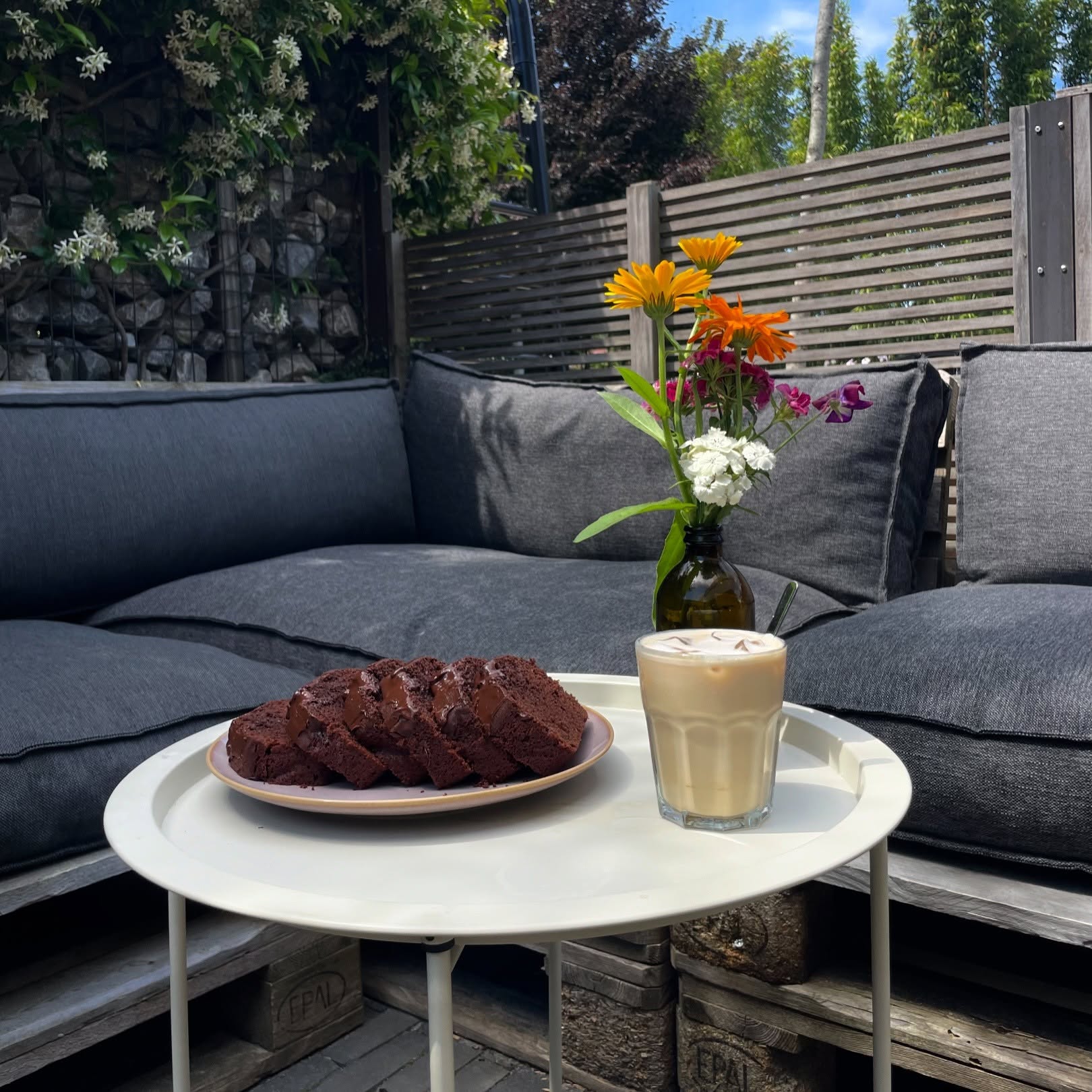 Brownie met een glas ijskoffie op een tafeltje op het terras